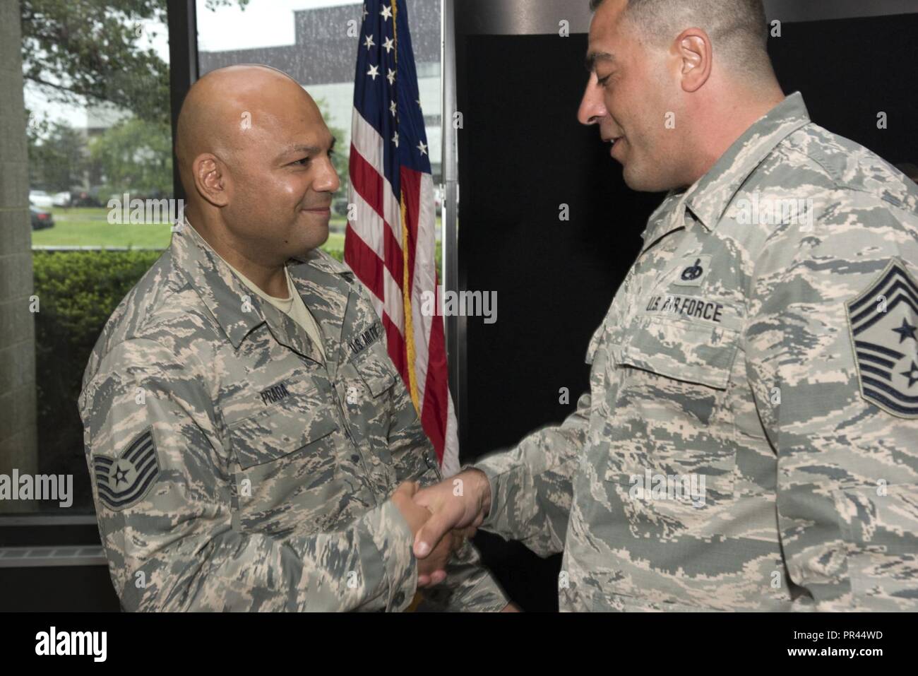 Chief Master Sgt. Mark Cozzupoli, command chief of the 105th Airlift Wing,  coins Tech. Sgt. Federico Prada, a recruiter assigned to the 105th AW at  Stewart Air National Guard Base, N.Y. Sept.