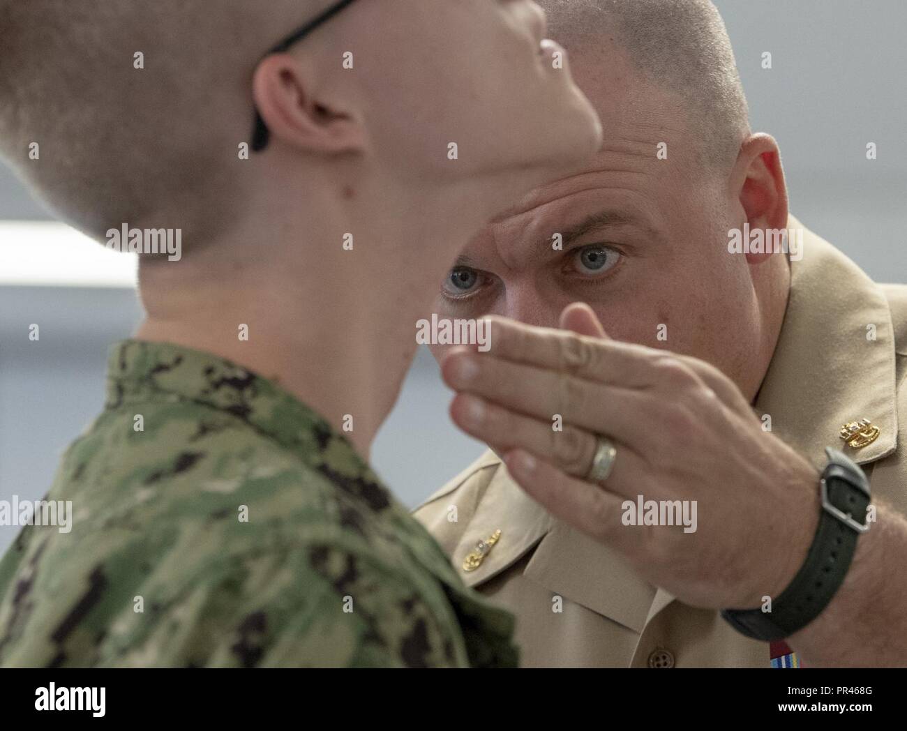 GREAT LAKES, Ill. (Sept. 10, 2018) Chief Operations Specialist James Conyne, a recruit division commander, inspects the quality of a recruit's shave before a personnel inspection inside a compartment in the USS Kearsarge barracks at Recruit Training Command (RTC). More than 30,000 recruits graduate annually from the Navy's only boot camp. Stock Photo
