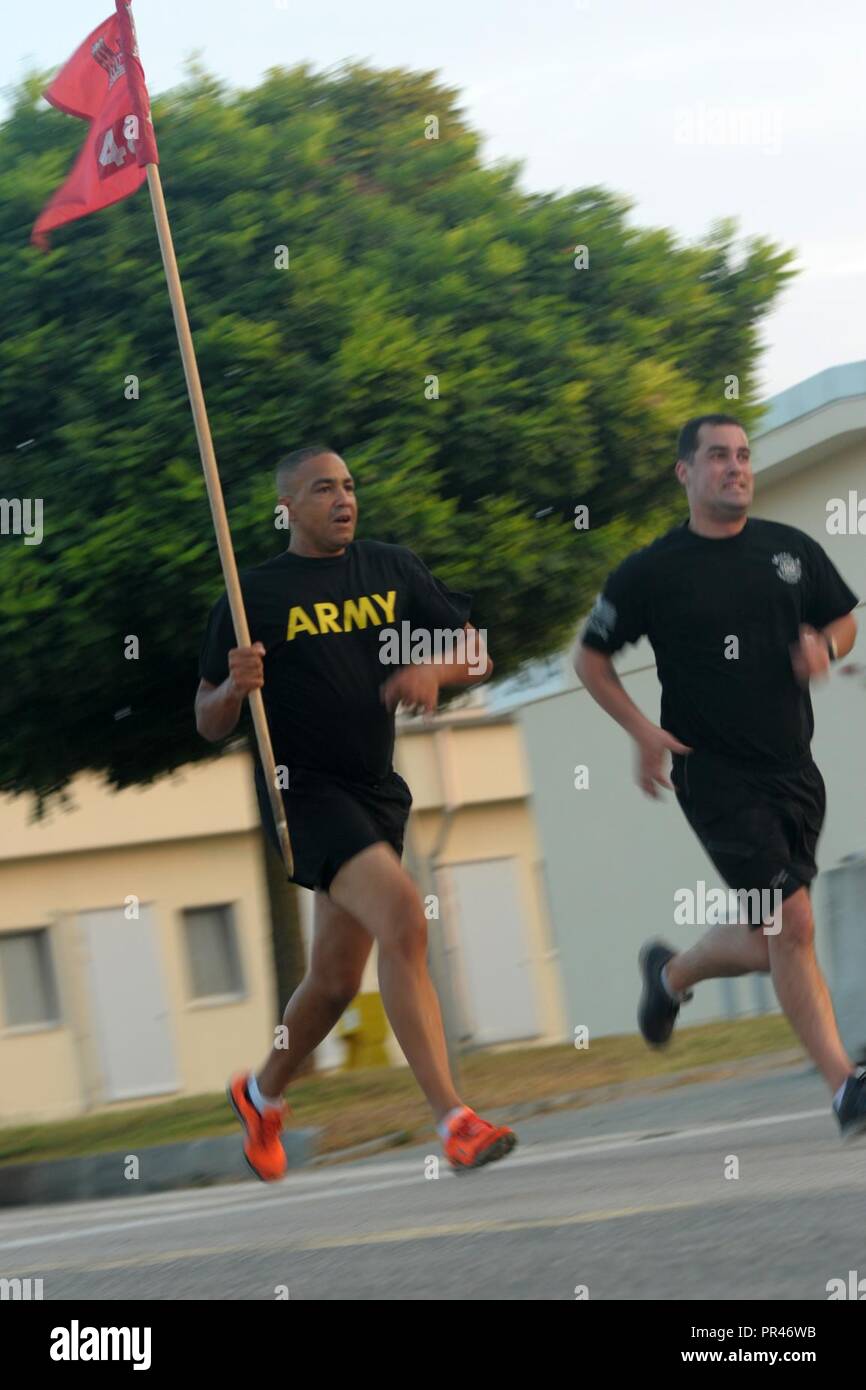 U.S. Army Sgt. 1st Class Norman Shoy, left, assigned to the 482nd Engineer Detachment, Firefighters Headquarters and U.S. Army Spc. Ettore Dimiceli of the 336th Engineer Detachment run with the unit's guidon during a five-kilometer run as part of 9/11 memorial event with more than 100 U.S. Soldiers and Airmen and Romanian, Canadian armed forces members and civilian staff participating in the run at Mihail Kogalniceanu Air Base in Romania, Sept. 11, 2018.  The run took place to remember the 2,996 lives taken during the attack on the World Trade Center and the Pentagon 17 years ago. Stock Photo