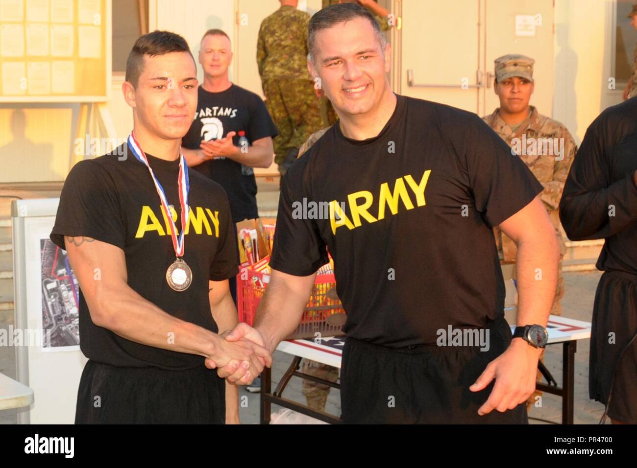 Pfc. Dominic Belanger, left, and Army Lt. Col. Christopher Marquez, Mihail Kogalniceanu Garrison Commander, shake hands after Belanger's third-place finish in a five-kilometer run held as part of a 9/11 memorial event with more than 100 U.S. Soldiers, Airmen, Romanian and Canadian armed forces and civilian staff participating in the run at Mihail Kogalniceanu Air Base in Romania, Sept. 11, 2018.  The run took place to remember the 2,996 lives taken during the attack on the World Trade Center and the Pentagon 17 years ago. Stock Photo