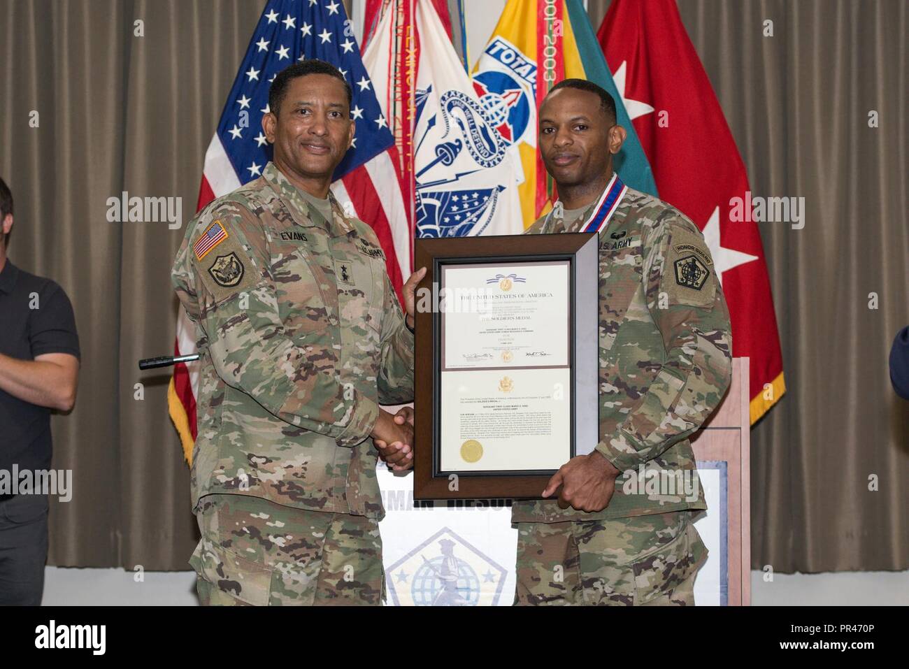 MG Jason T. Evans (left) presents SFC Mario King with the