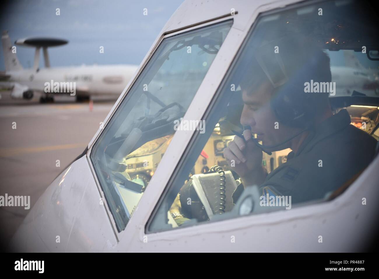 Capt. Josh Archer, an E-3G Airborne Warning and Control System pilot, reads back his clearance during pre-flight operations in the early morning of Sept. 15, 2018 at Tinker Air Force Base, Oklahoma. Capt. Archer and his crew are from the 552nd Air Control Wing, 960th Airborne Air Control Squadron, based at Tinker AFB and are shown preparing for a mission supporting the response to Hurricane Florence Sept. 15, 2018, Tinker Air Force Base, Oklahoma.  The AWACS will provide air control and de-confliction service along the East Coast of the United States as they monitor and control airspace as loc Stock Photo