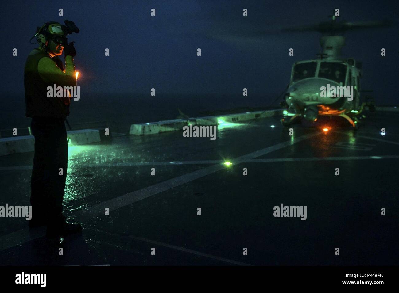 INDIAN OCEAN (Dec. 30, 2017) Aviation Boatswain Mate Handling Airman Ryan Sharland, from Newport Beach, Calif., directs A UH-1Y Venom, assigned to Marine Medium Tiltrotor Squadron (VMM) 161 (reinforced), on the flight deck of the amphibious transport dock ship USS San Diego (LPD 22). San Diego, part of the America Amphibious Ready Group, with embarked 15th MEU, is operating in the Indo-Asia-Pacificregion to strengthen partnerships and serve as a ready-response force for any type of contingency. Stock Photo