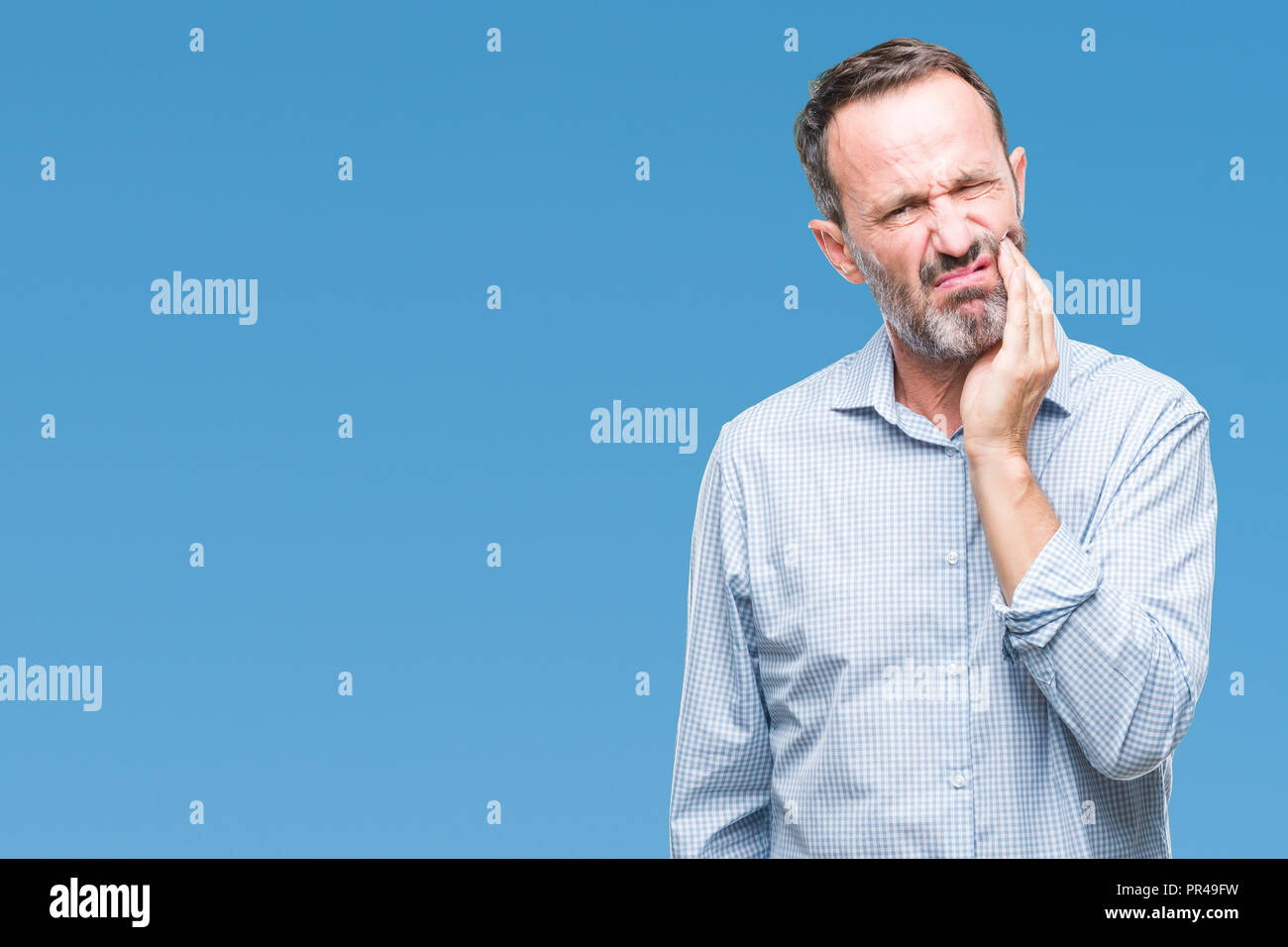 Middle age hoary senior business man over isolated background touching mouth with hand with painful expression because of toothache or dental illness Stock Photo