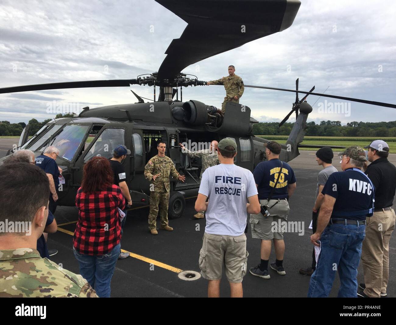 U.S. Army Chief Warrant Officer 2 Greg Gallerizzo, with Alpha Company, 2-104th General Support Aviation Battalion, 28th Expeditionary Combat Aviation Brigade, briefs civilian first responders from Snyder County, Pennsylvania on the UH-60 Black Hawk helicopter at Penn Valley Airport, Sept. 8, 2018. Civilian first responders learned how to handle the unique nature of military aviation accidents, should they encounter one. 28th ECAB soldiers trained attendees on aircraft orientation, hazard identification, emergency egress for injured flight crew members, emergency battery fuel and battery shut o Stock Photo