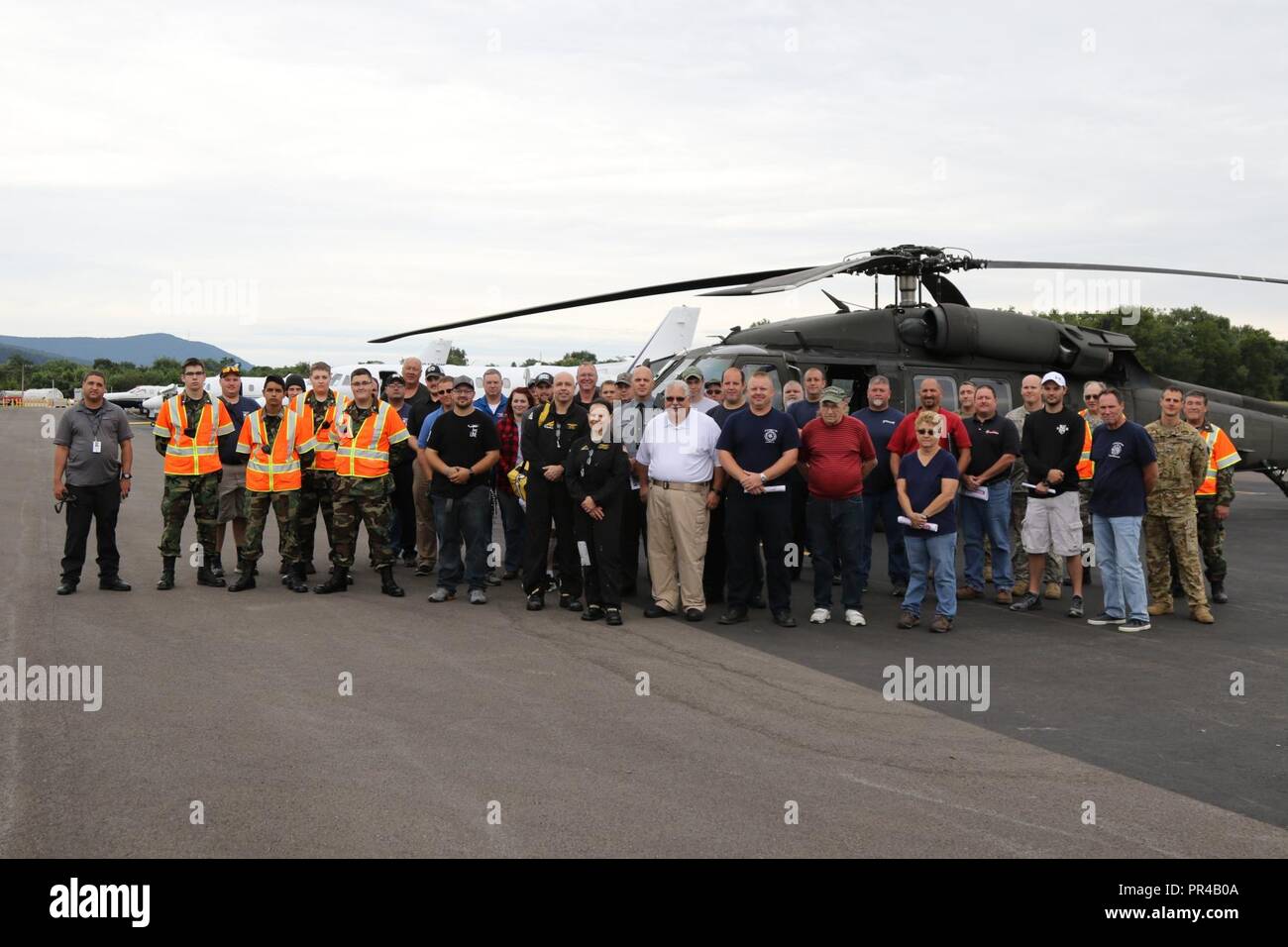 Pennsylvania Army National Guard aviators and members of various civilian organizations including emergency management personnel, Pennsylvania State Police, the Civil Air Patrol, EMS personnel, and other first responders stand side by side for a group photo after a joint aviation training exercise at the Penn Valley Airport in Selinsgrove, Snyder County, Pa. Sept. 8, 2018. The exercise provided the civilian participants with hands-on learning on the UH-60 Blackhawk helicopter, in the event that they should be the first to arrive on-scene at a potential crash site of the Pennsylvania Army Natio Stock Photo