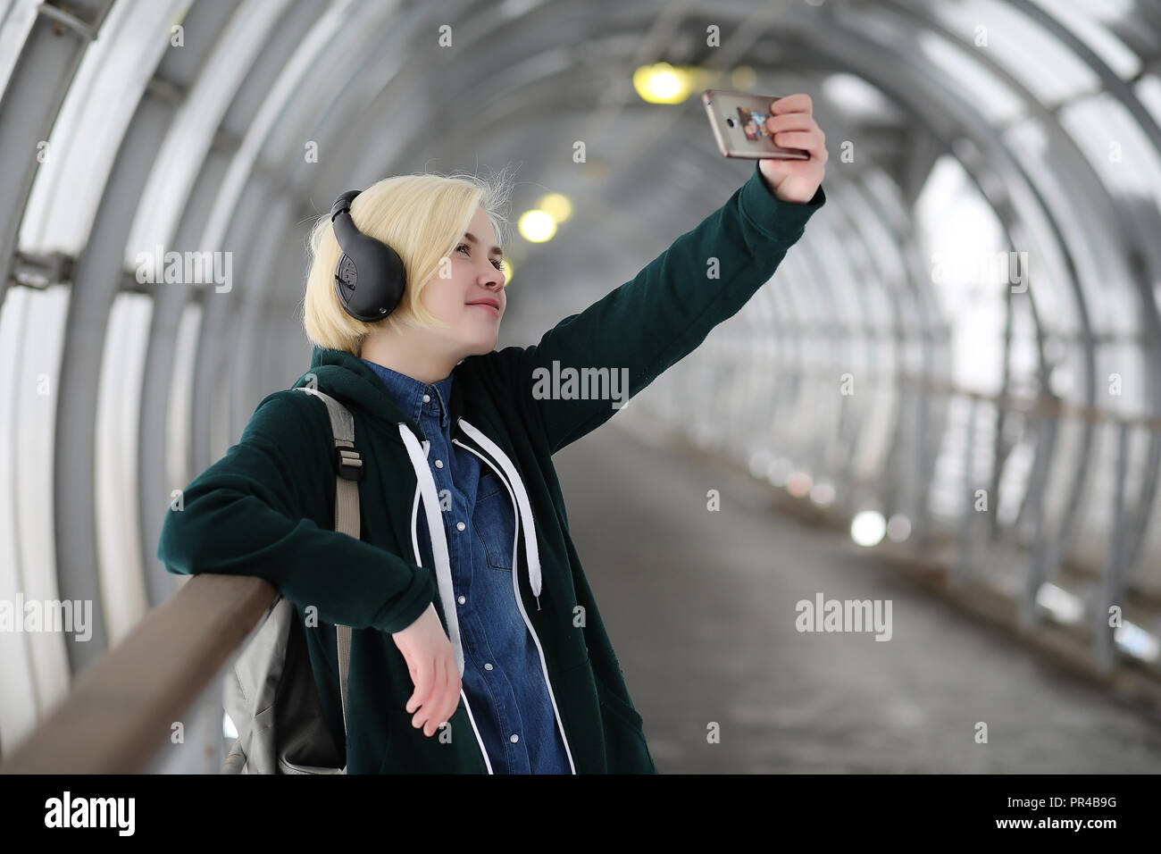 Young girl listens to music in big headphones in the subway Stock Photo Alamy