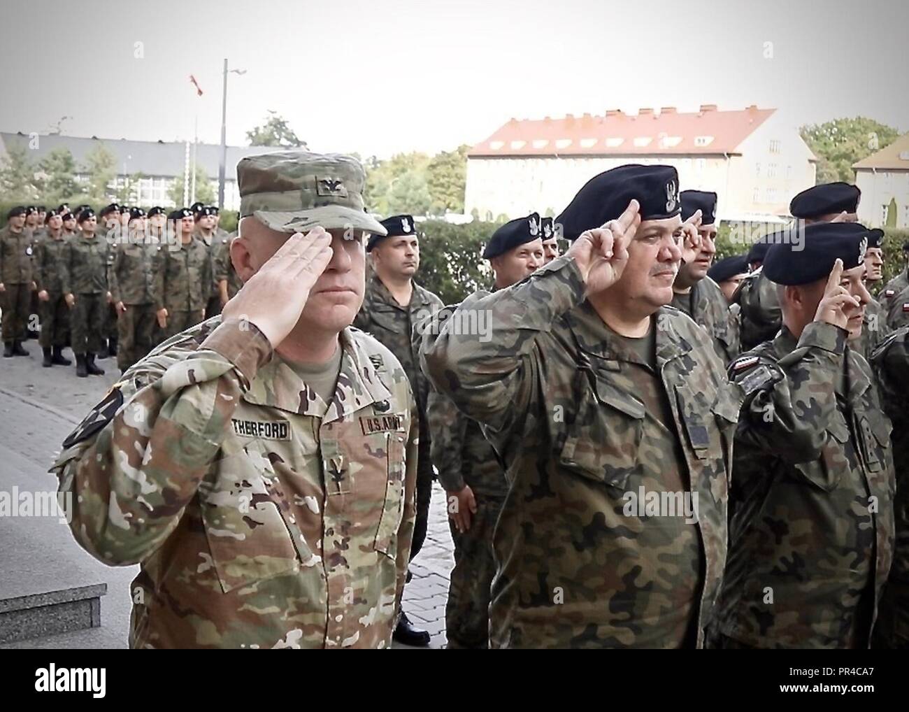 U.S. Army Col. Wilson Rutherford, IV, the commander of the 1st Armored Brigade Combat Team, 1st Cavalry Division, Polish Maj. Gen. Stanislaw Tchosneck, the commander of the 11th Armoured Cavalry Division, Soldiers assigned to the 91st Brigade Engineer Battalion, 1st ABCT, 1st CD, and Polish soldiers pause from their training to remember the terrorist attacks of Sept. 11 at Boleslaweic, Poland. Sept. 11, 2018. The Ironhorse brigade is currently deployed throughout Europe in support of Atlantic Resolve. Stock Photo