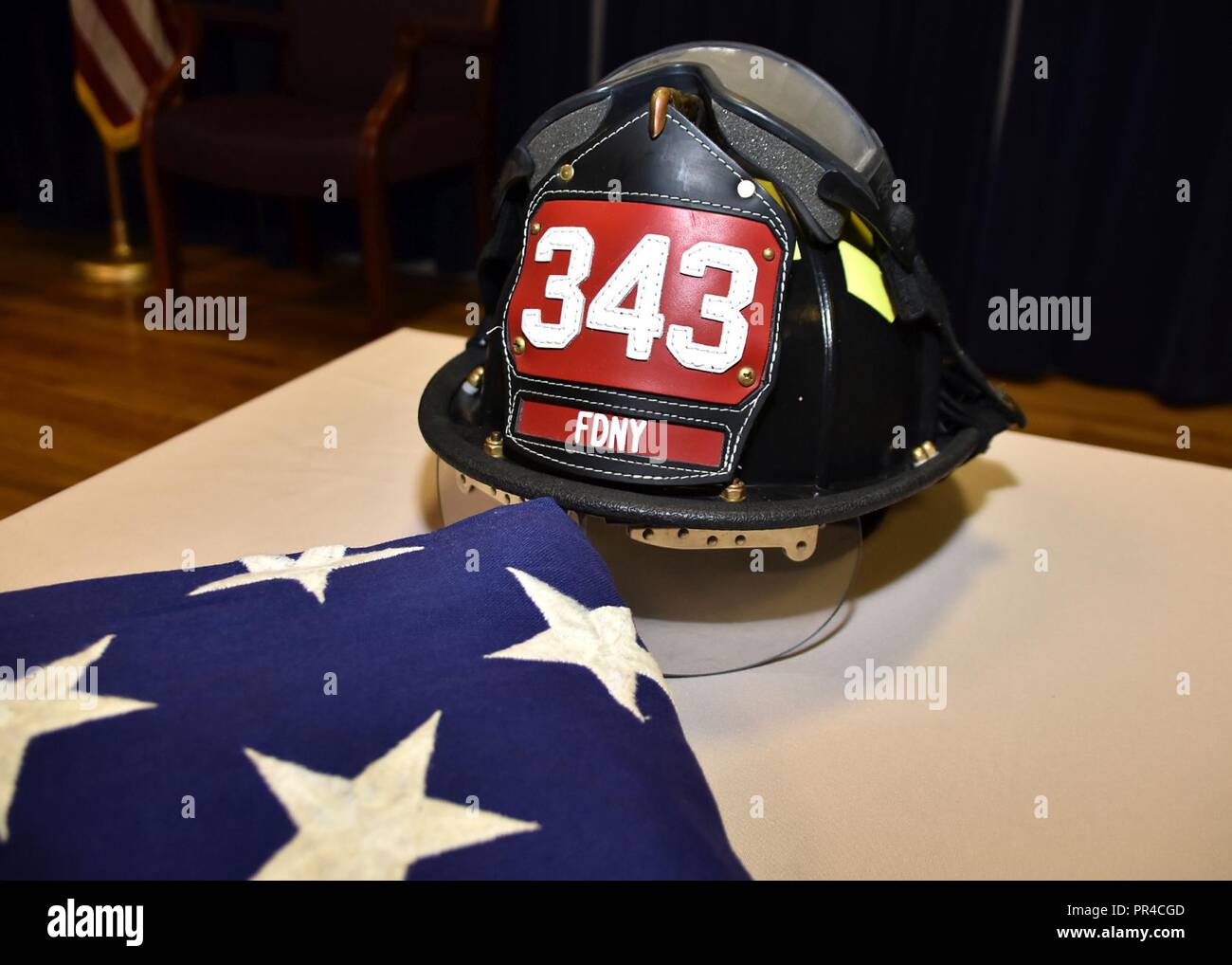 A firefighter's helmet and an American flag are on display during a 143d  Airlift Wing remembrance for the first responders who perished during the  Sept. 11, 2001 attacks, on Sept. 11, 2018,