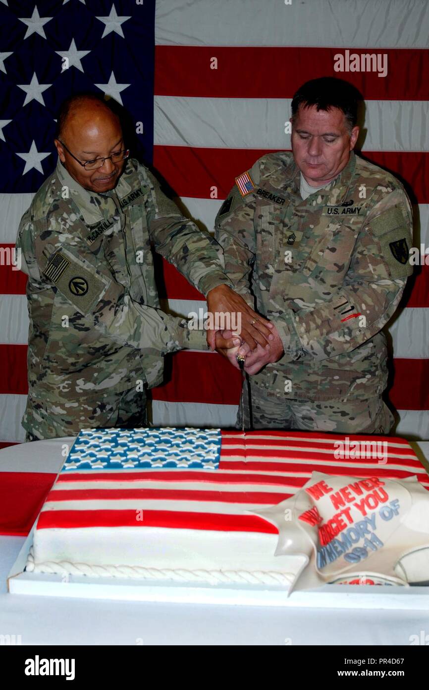 U.S. Army Chaplain Lt. Col. Henry McCaskill Jr., left, and U.S. Army Master Sgt. Brian Breaker cut a cake during a 9/11 memorial event at Mihail Kogalniceanu Air Base in Romania, Sept. 11, 2018.  The event honored the 2,996 lives taken during the attack on the World Trade Center and the Pentagon 17 years ago. Stock Photo