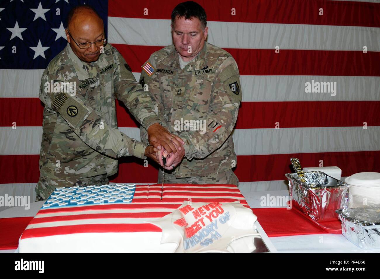 U.S. Army Chaplain Lt. Col. Henry McCaskill Jr., left, and U.S. Army Master Sgt. Brian Breaker cut a cake during a 9/11 memorial event at Mihail Kogalniceanu Air Base in Romania, Sept. 11, 2018.  The event honored the 2,996 lives taken during the attack on the World Trade Center and the Pentagon 17 years ago. Stock Photo