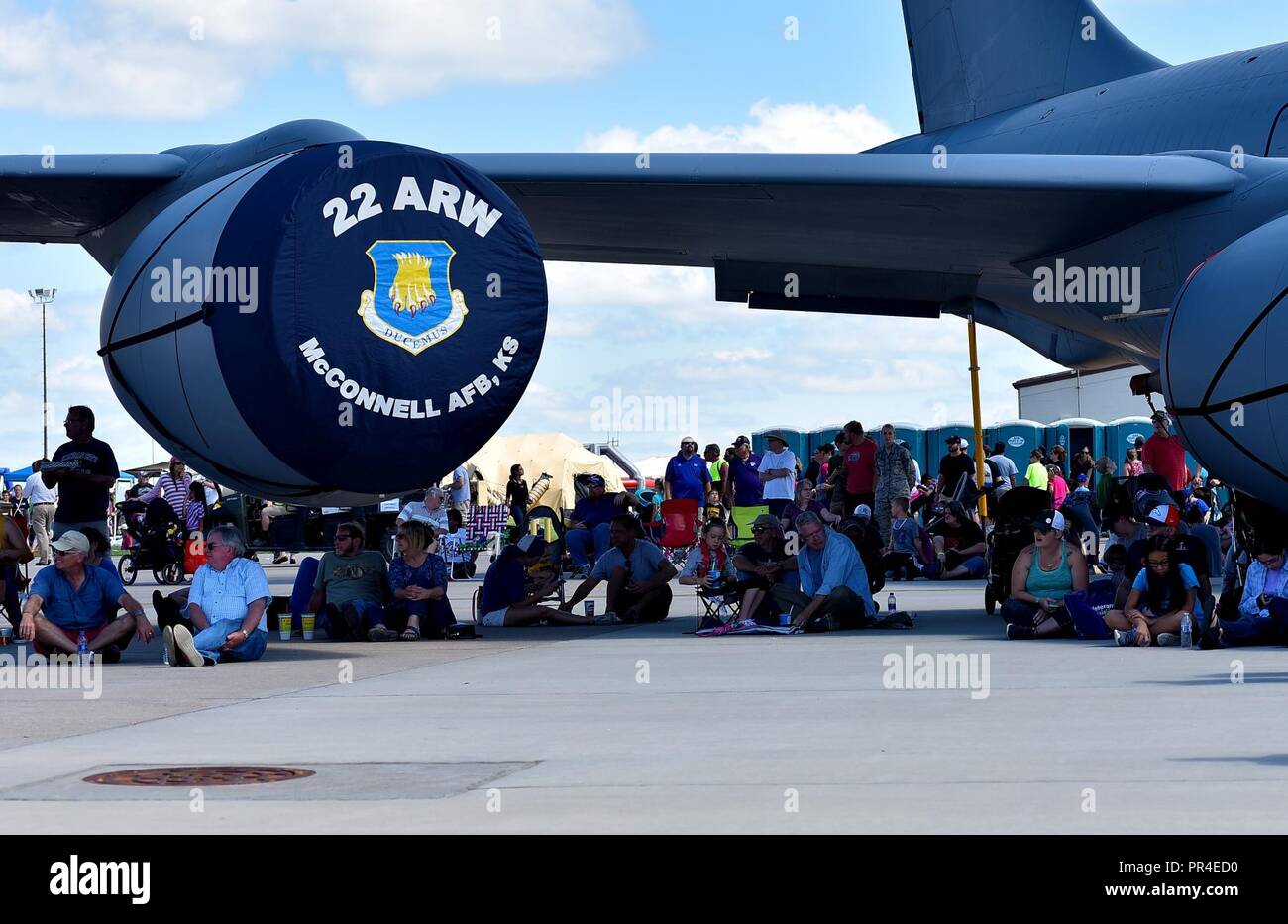 Members of the crowd shelter themselves from the sun under the wing of a KC-135 Stratotanker during the Frontiers in Flight Open House and Air Show Sept. 9, 2018, at McConnell Air Force Base, Kansas. The KC-135 is the backbone of the aerial refueling fleet and has been in service for 62 years. Stock Photo