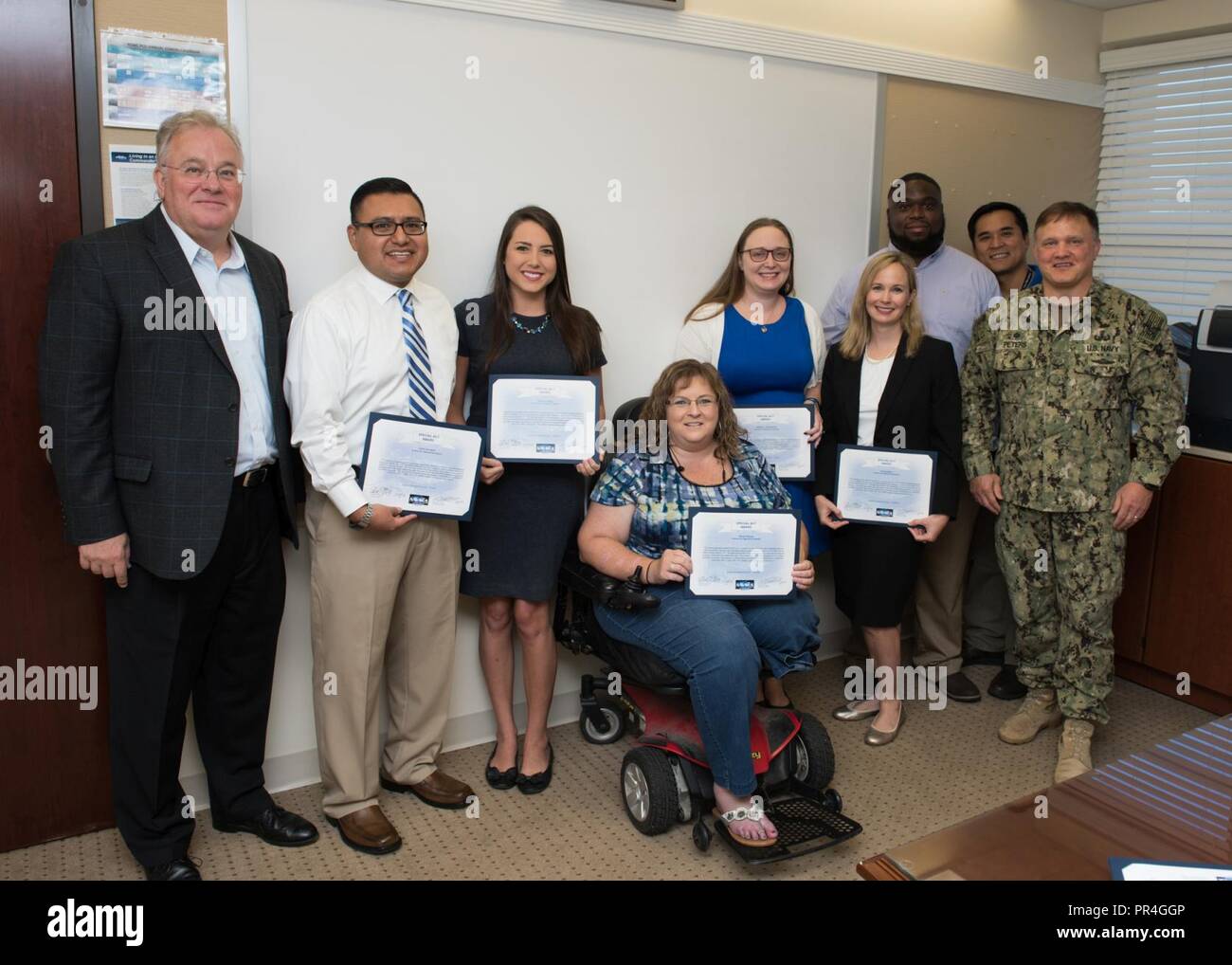 PANAMA CITY, Florida - Naval Surface Warfare Center Panama City Division (NSWC PCD) personnel, who are part of the interdisciplinary Naval Sea Systems Command (NAVSEA) People's Integrated Essential Resource (PIER) team, are recognized with a Special Act Award for their contributions to the NAVSEA Enterprise project Sept. 13, 2018. Pictured from left to right: NSWC PCD Technical Director Ed Stewart (SES), David Galindo, Katherine Mapp, Allison Roberts, Kimberly Ten Broeck, Holly Gardner, Keely Westbrook, Vatana An, and NSWC PCD Commanding Officer Capt. Aaron Peters, USN. U.S. Navy Stock Photo