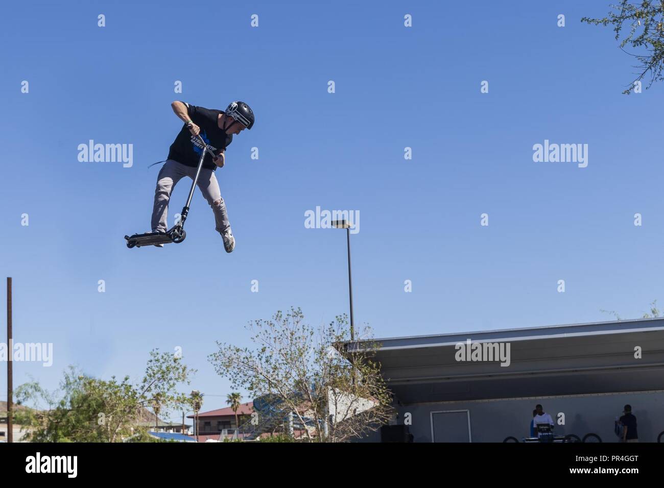 Bransyn Smith, professional Razor Scooter rider and X-Games athlete,  performs a tail whip off of a box jump during the X-Games Action Sports  Show at the Marine Corps Exchange parking lot aboard