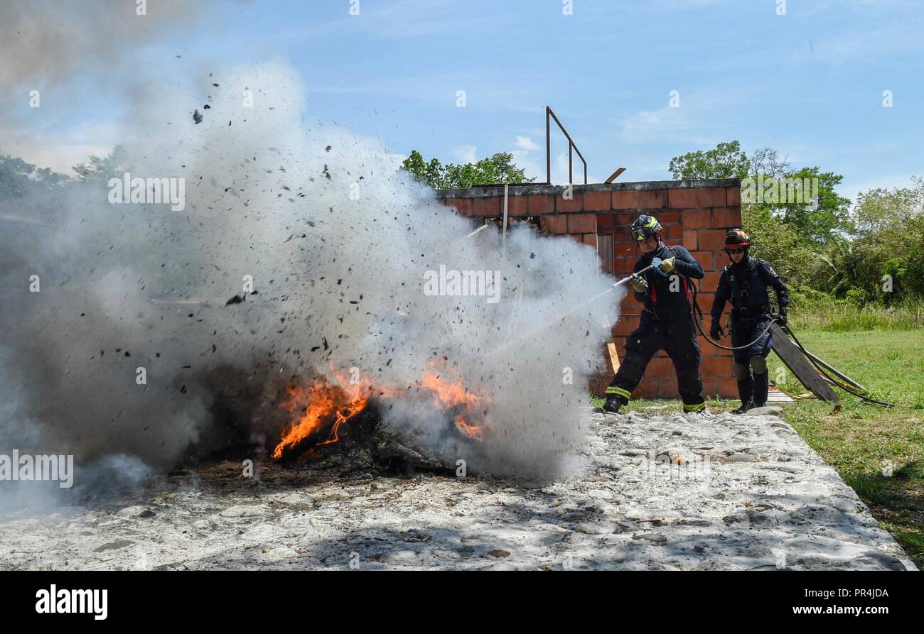 Colombian firefighters put out a fire during a mass casualty earthquake simulation as part of the multilateral exercise Angel de los Andes Sept. 6, 2018, at German Olano Air Base, Colombia. The first week of the exercise is focused on responding to natural disaster scenarios that include an earthquake response, a forest fire and an open water rescue, as well as responding to an aircraft crash. Stock Photo