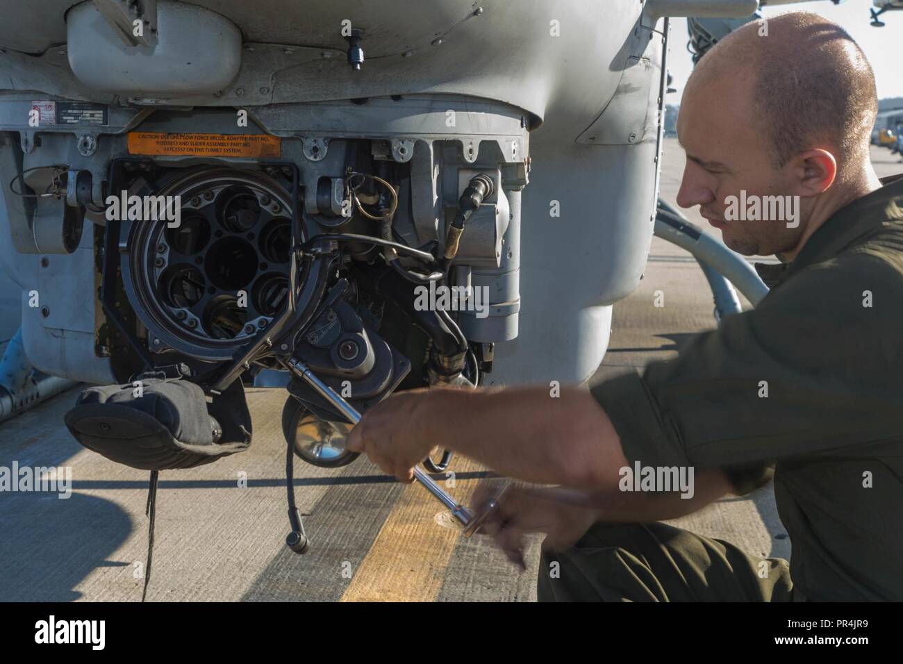 U.S. Marine Corps Lance Cpl. Antony Thompson, ordinance technician, Marine Light Attack Helicopter Squadron 775, 4th Marine Aircraft Wing, unscrews a bolt during an inspection of a M197 turret mounted on a Bell AH-1Z Viper Attack Helicopter at Marine Corps Air Station Camp Pendleton, California, Sept. 14, 2018. Turret inspections are conducted every 56 days. Stock Photo