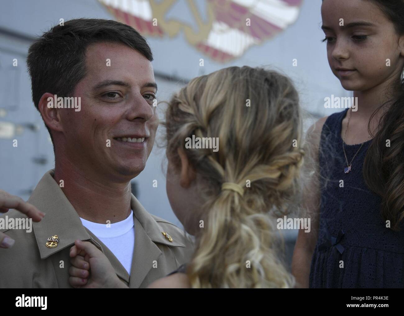 SAN DIEGO (Sept. 14, 2018) Chief Aviation Ordnanceman Ryan Heeney is pinned by his daughters during a chief pinning ceremony on the flight deck of amphibious assault ship USS Boxer (LHD 4). The ceremony was the culmination of six weeks of training indoctrination during Sailor 360, phase II. Boxer is pierside in its homeport for contractor maintenance availability. Stock Photo