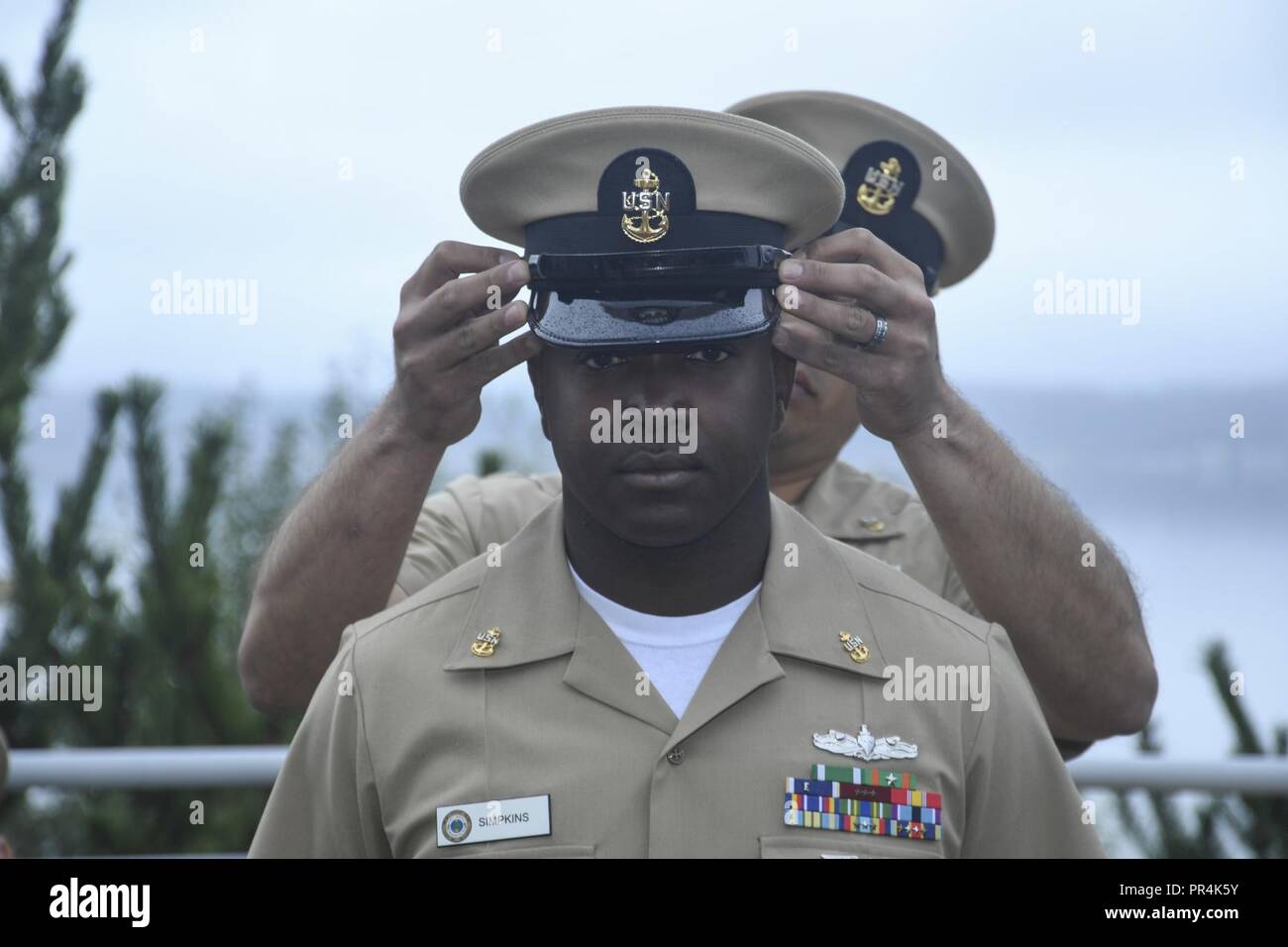 Wash. (Sept. 14, 2018) - Chief Culinary Specialist Donald Simpkins, a native of Montgomery, Ala., has his chief petty officer (CPO) cover placed upon his head by Senior Chief Hospital Corpsman Brian Nielson during Naval Hospital Bremerton's (NHB) CPO pinning ceremony. During the ceremony, five Sailors from NHB received their anchors. Stock Photo