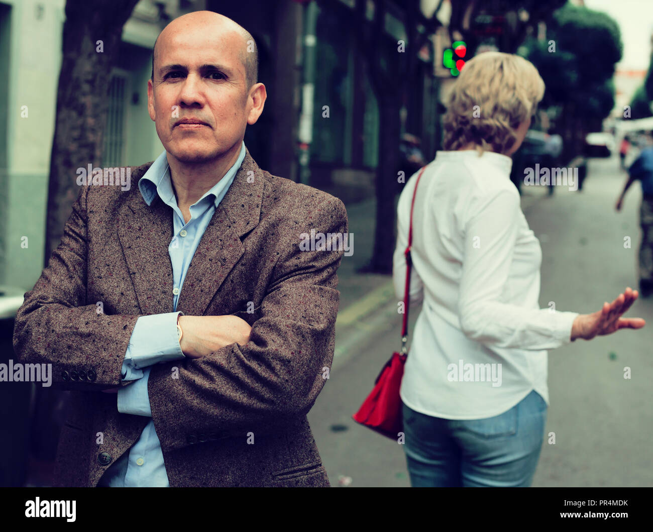 irritated senior man standing back to annoyed woman outdoors Stock ...
