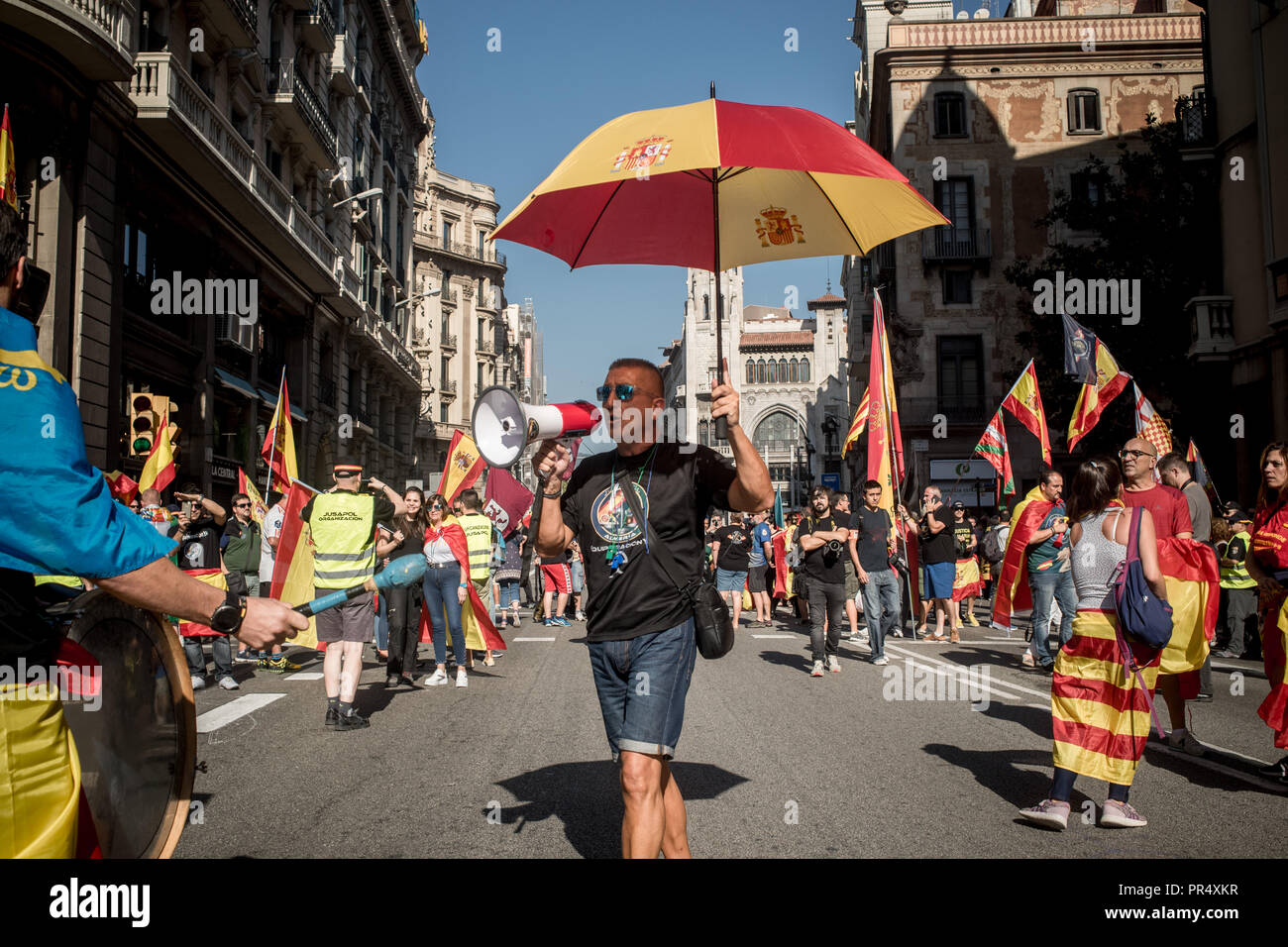 September 29, 2018 - Barcelona, Catalonia, Spain -  A man carrying and umbrella with the spanish flag colors shouts slogans during a Spanish police demonstration in Barcelona. Members and supporters of Spanish police Guardia Civil and Policia Nacional marched by Barcelona streets demanding salary improvements and in tribute to the participation against the Catalan referendum of independence a year ago. Stock Photo