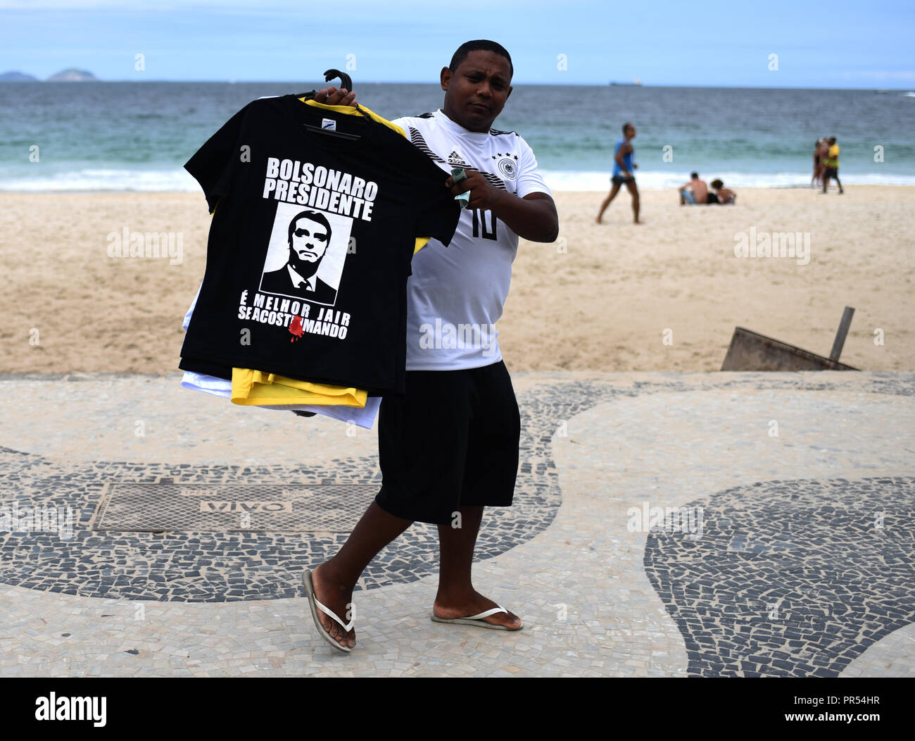 Rio de Janeiro, Brazil. 29th Sep, 2018. A man sells T-shirts at Copacabana beach to support right-wing presidential candidate Bolsonaro. This Saturday, rallies against the ex-military are also expected. Bolsonaro is the favourite in the presidential election on 7 October, since a court banned the candidacy of detained ex-president Lula da Silva. Brazil's "trump card" has been involved in politics for a long time, but has recently presented itself as an anti-system candidate. Credit: Fabio Teixeira/dpa/Alamy Live News Stock Photo