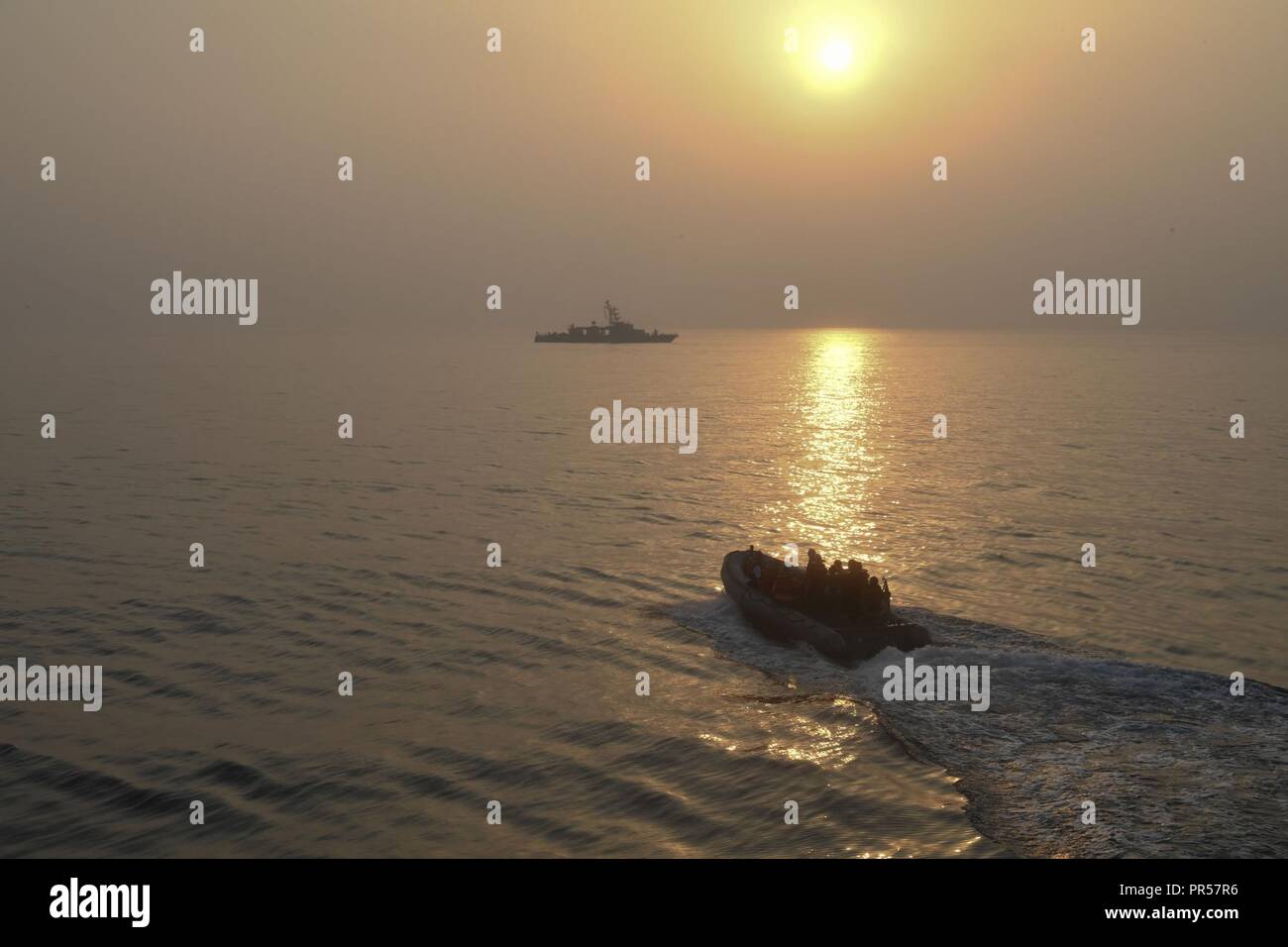 ARABIAN GULF (Sept. 16, 2018) A rigid-hull inflatable boat steers toward coastal patrol ship USS Thunderbolt (PC 12) prior to  a MK-60 Griffin guided missile system shoot. Ships attached to U.S. 5th Fleet's Task Force 55 are conducting Griffin surface-to-surface missile and naval gun exercises against high speed maneuvering targets to advance their ability to defend minesweepers and other coastal patrol ships. U.S. 5th Fleet and coalition assets are participating in numerous exercises as part of the greater Theater Counter Mine and Maritime Security Exercise to ensure maritime stability and se Stock Photo