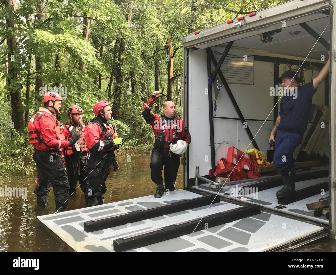 Coast Guard works with partner agencies in Lumberton, N.C.    Chief Petty Officer John Mitchell, a shallow-water response boat team member, coordinates rescue efforts with the New Cumberland County River Rescue team from New Cumberland, Pennsylvania, in the Mayfair neighborhood of Lumberton, North Carolina, Sept. 17, 2018.    Shallow-water response teams use 16-foot aluminum boats in order to navigate areas flooded by Hurricane Florence and to provide assistance in coordination with state and local emergency operation centers.    U.S. Coast Guard Stock Photo