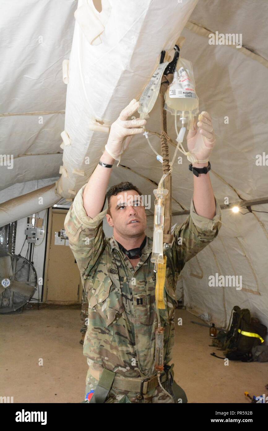 CPT Michael Broussard, 75th Ranger Regiment, checks on an IV providing ...