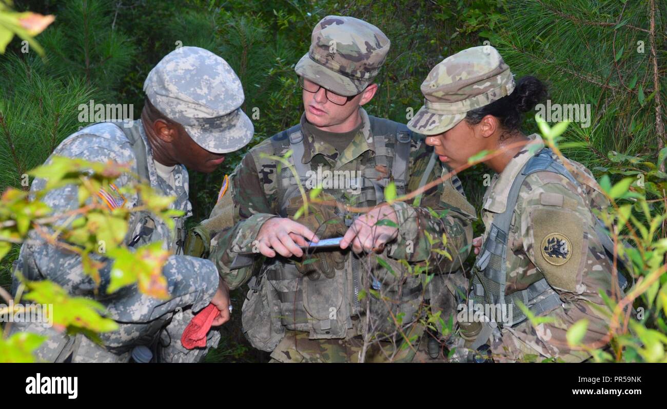 Georgia Army National Guardsmen Sgt. William Sanders, an infantryman with the Cordele-based, Charlie Company 2nd Battalion 121st Infantry, accompanies Cpl. Kentavious Patman, a military policeman with the Kennesaw-based, 190th Military Police Company and Spc. Shanita Capers, an automated logistics specialist with the Tifton-based, Headquarters, 110th Combat Support Sustainment Battalion, conduct the land navigation exercise portion of the Noncommissioned Officer Induction Course at Fort Stewart, Ga. on Sept. 17, 2018. The exercise required Soldiers to locate and travel t five points on a map p Stock Photo