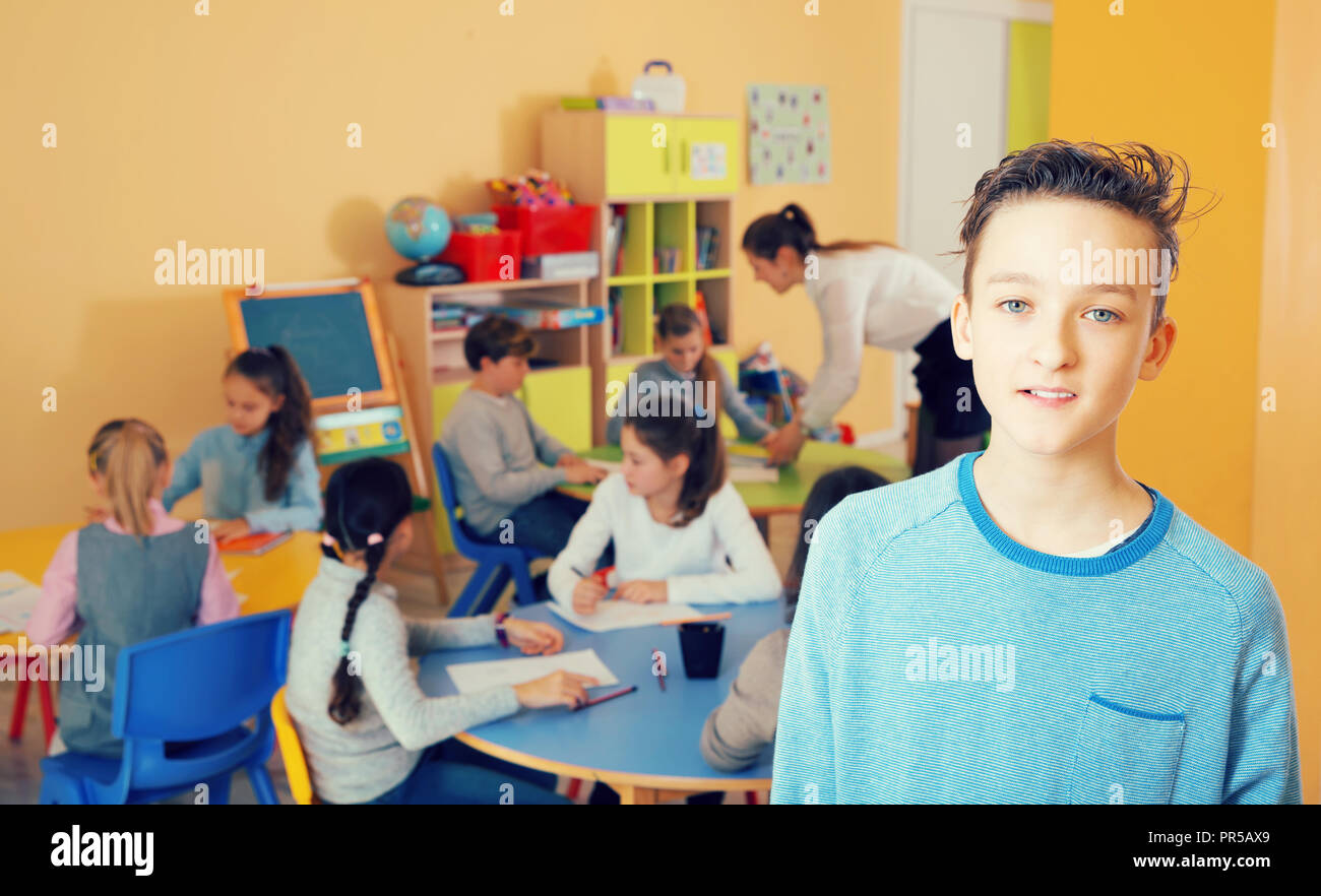 Schoolboy standing, elementary age children drawing at class Stock ...