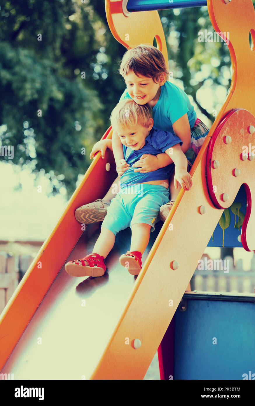 girls on slide at playground area in summer Stock Photo - Alamy