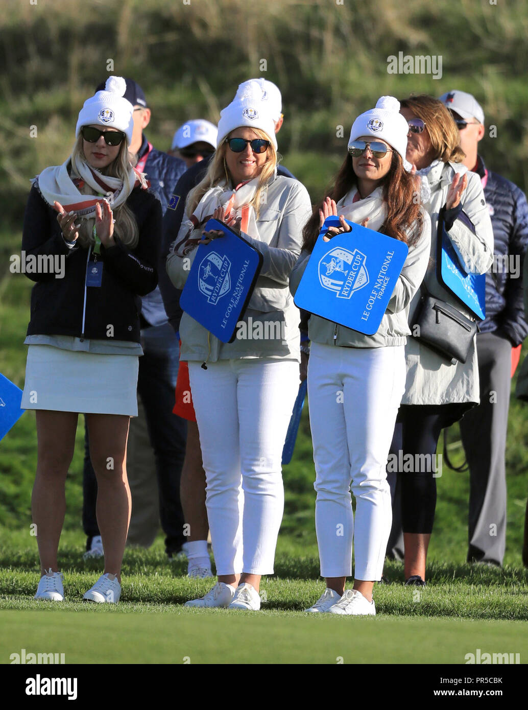 Katie Poulter, wife of Ian Poulter (centre) and Kelley Cahill (left), girlfriend of Jon Rahm during the Fourballs match on day two of the Ryder Cup at Le Golf National, Saint-Quentin-en-Yvelines, Paris. Stock Photo