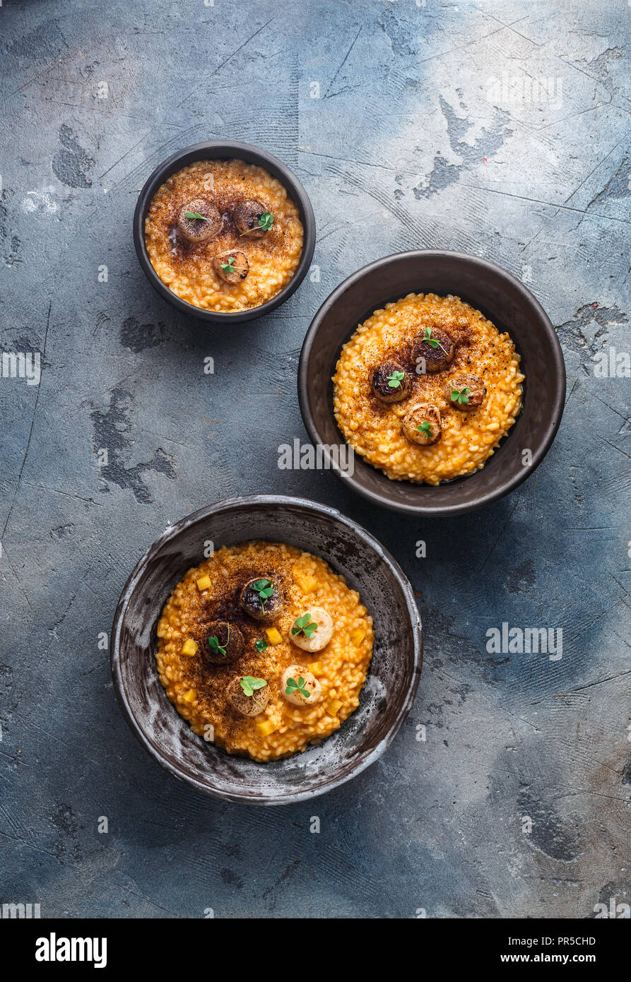 Three risotto bowl on stone background, top view Stock Photo - Alamy