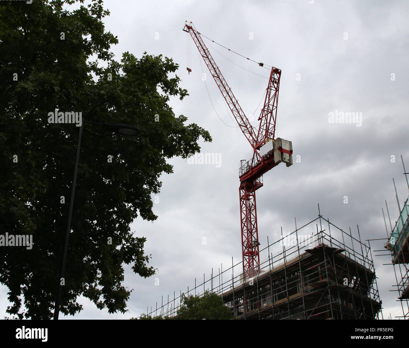 Construction crane towers on cloudy sky with some background Stock ...