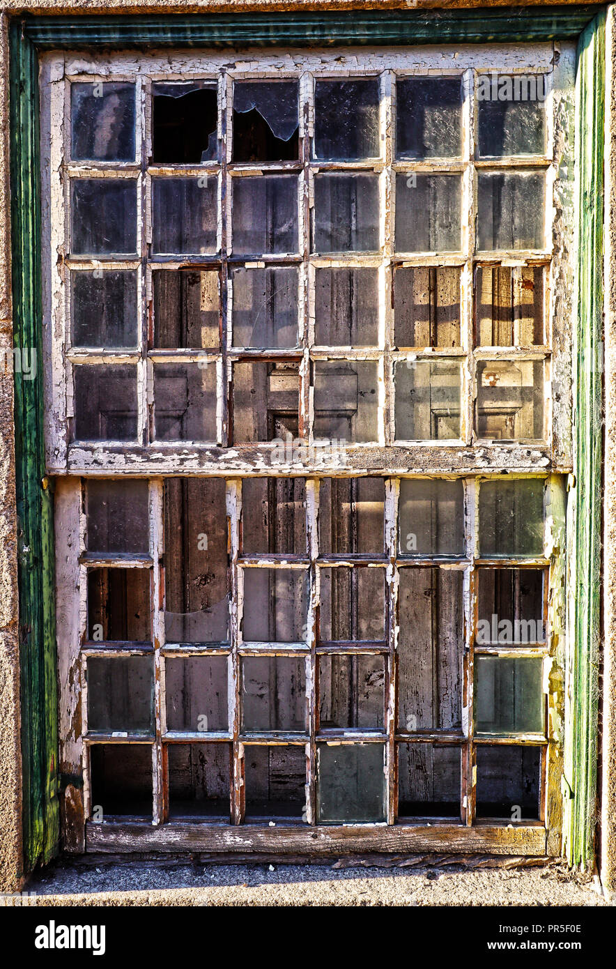 An ornate window with shutters behind in a derelict building, Vila Cova