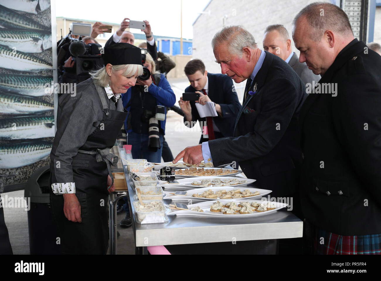 The Prince of Wales known as the Duke of Rothesay whilst in Scotland, views a seafood stall during a visit to Peterhead fish market for the opening of the new North Bay market building. Stock Photo
