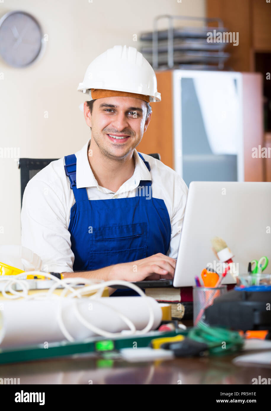 Positive designer-constructor with tools and documentation at work ...