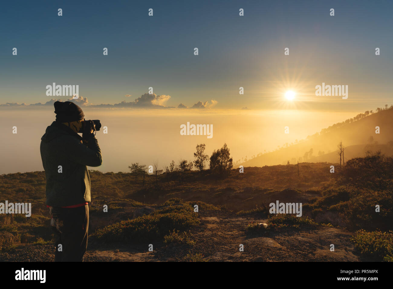 Traveller taking photograph of sunrise view on the mountain in the morning. Travel lifestyle Stock Photo