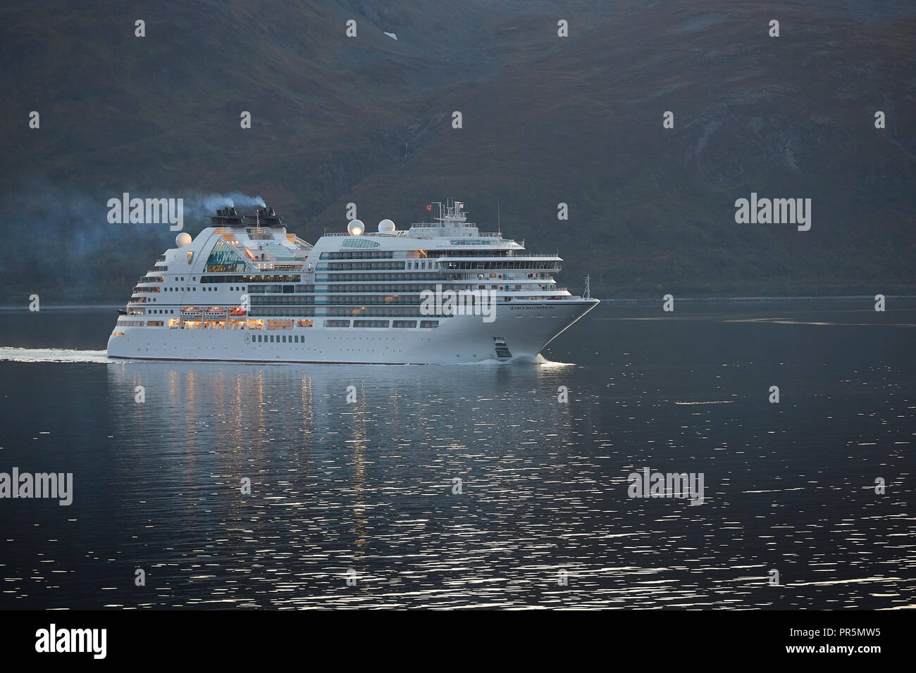 The Cruise Ship, Seabourn Ovation, Sails Through The Lauksundet, Close To  Skjervøy, North Of The Norwegian Arctic Circle At Sunset. Stock Photo