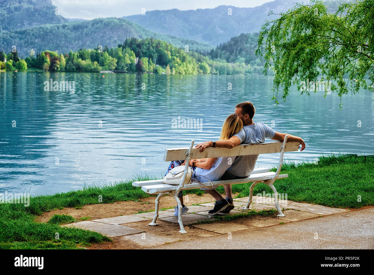 Romantic couple sitting on the bench at Bled Lake, Slovenia Stock Photo ...