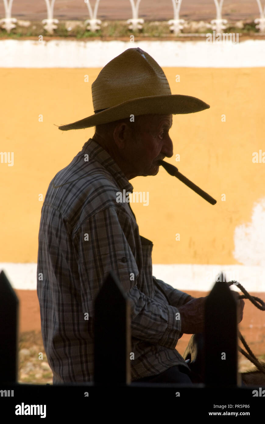 portrait of an old man profile with traditional hat and smoking cigar in the streets of Trinidad Cuba West Indies Stock Photo