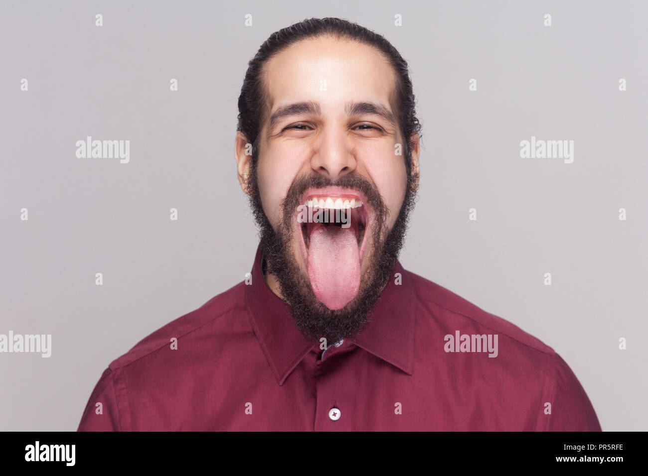 Portrait of funny crazy handsome man with beard in red shirt looking at  camera with big open mouth and tongue out and screaming or shouting. indoor  st Stock Photo - Alamy