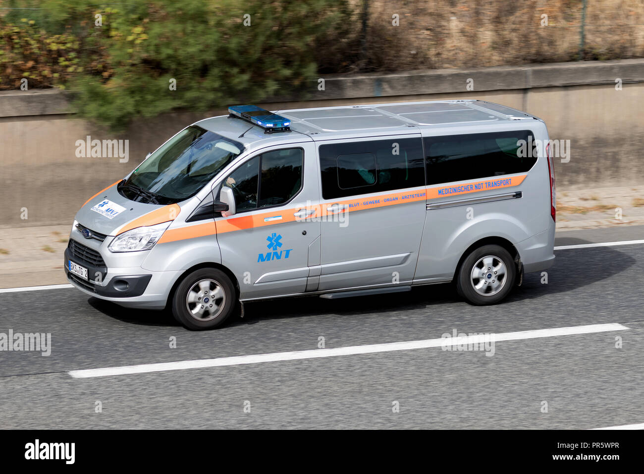 MNT van with active blue emergency vehicle lighting on motorway. Stock Photo