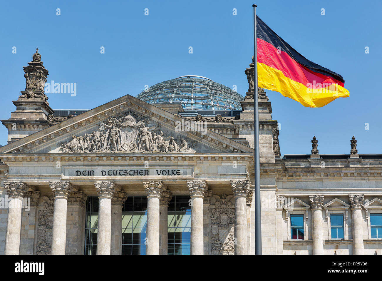 Closeup view of famous Reichstag building with German flag, seat of the German Parliament. Berlin Mitte district, Germany. Stock Photo