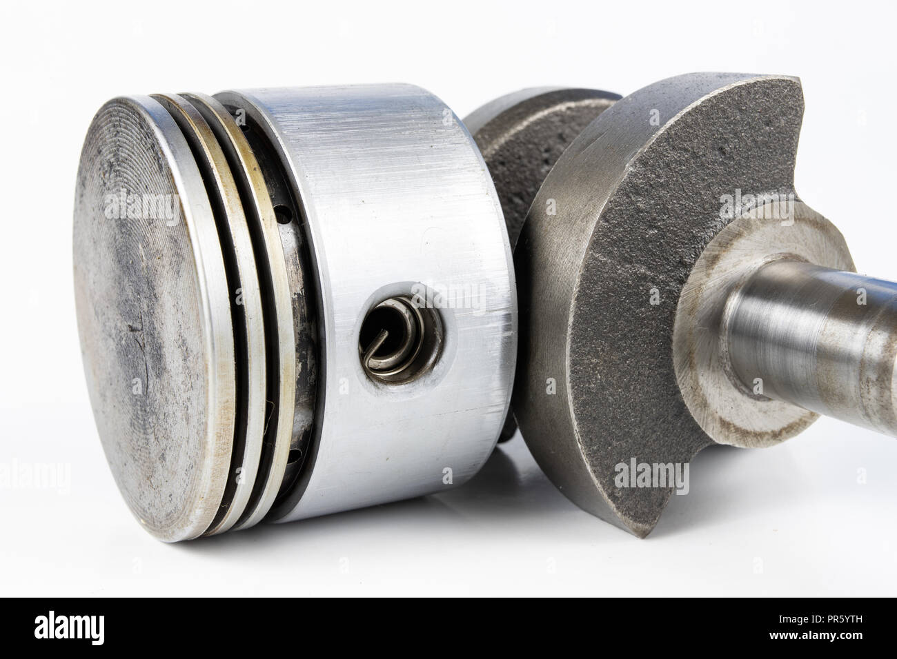 Crankshaft and piston of a small combustion engine on a white table