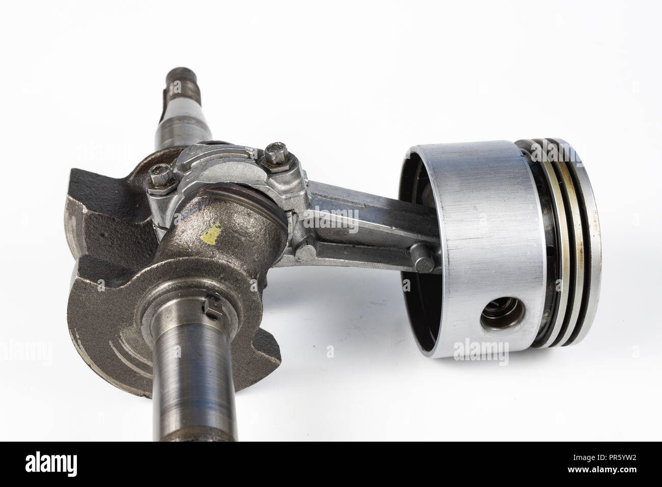 Crankshaft and piston of a small combustion engine on a white table