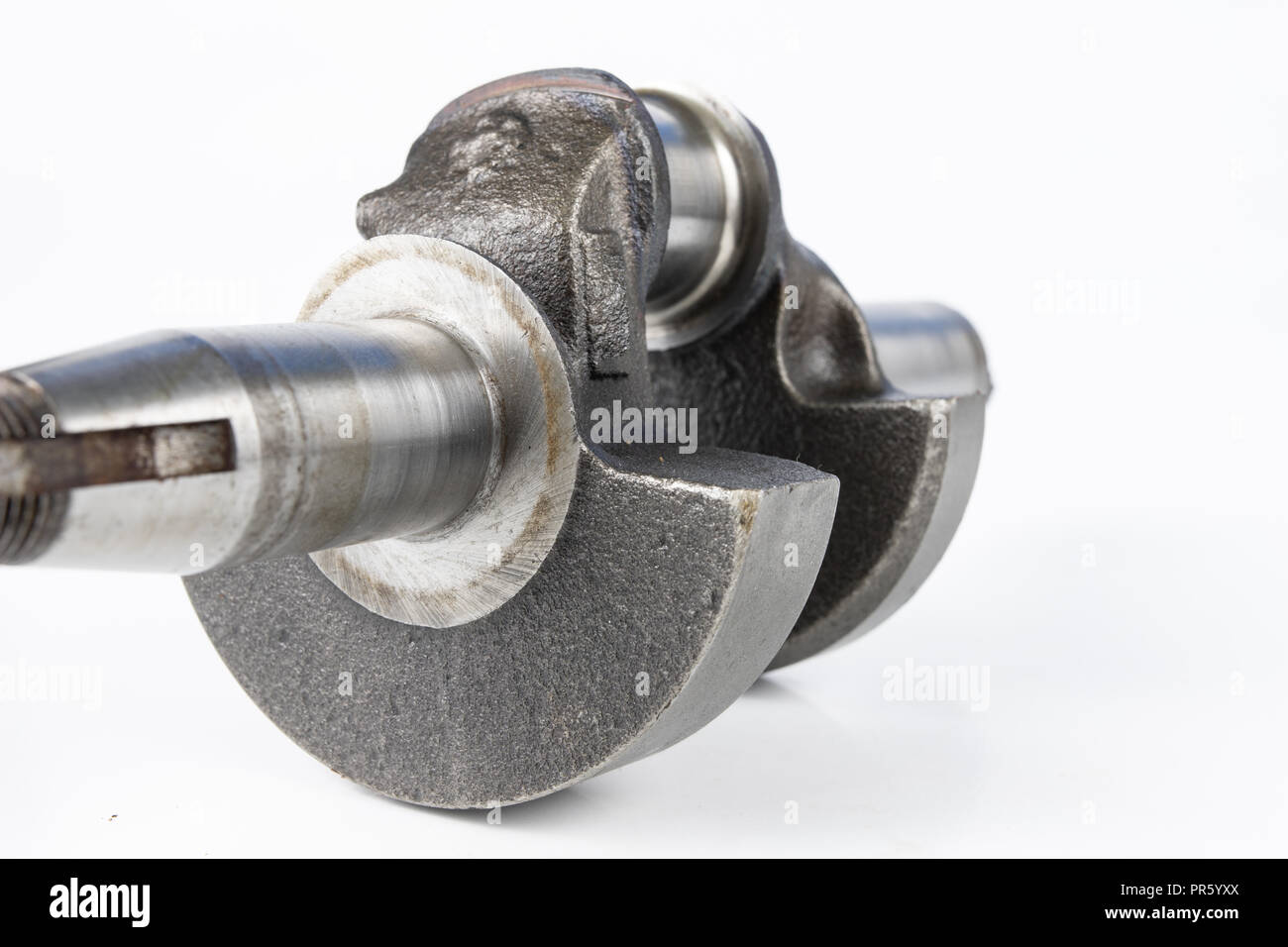 Crankshaft of a small combustion engine on a white table. Spare parts