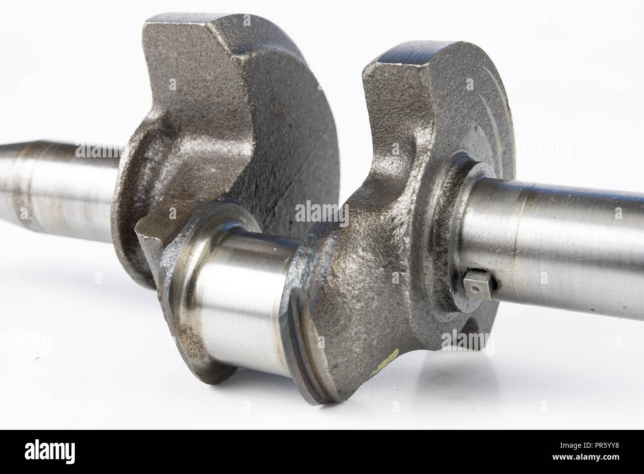 Crankshaft of a small combustion engine on a white table. Spare parts