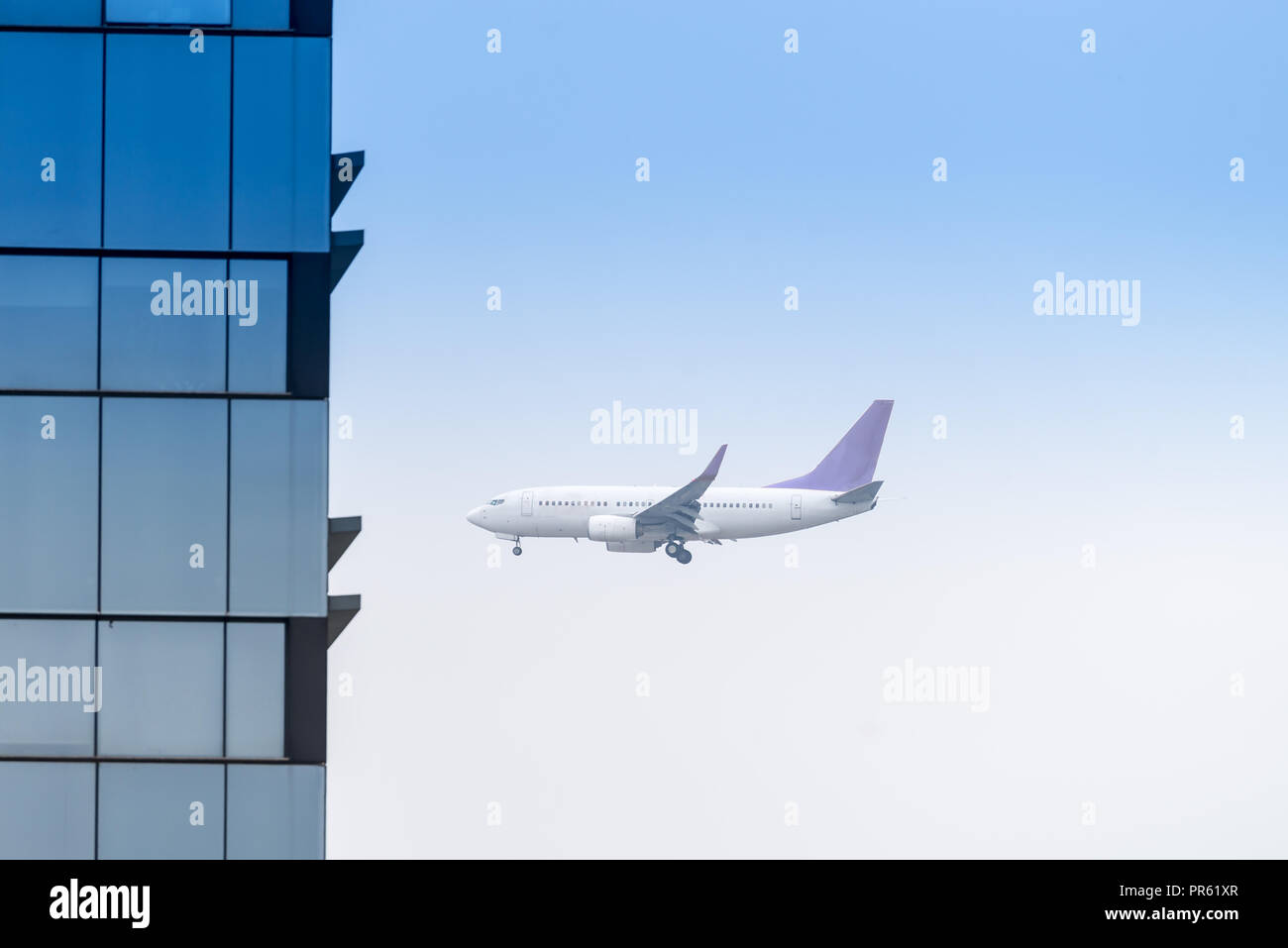 Airplanes flying through buildings at the big city town Stock Photo