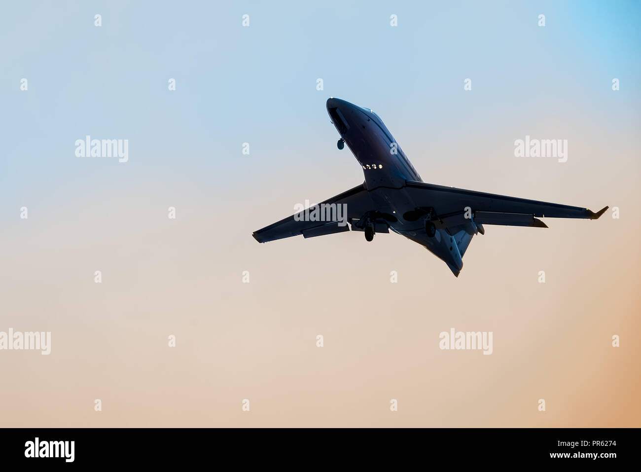 Big airplane flying high with detail of the land gear down Stock Photo